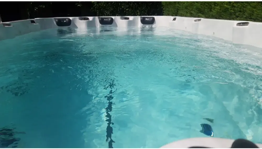 Vit PassionSpa Activity 1 Swim Spa med vit bad, turkost vatten och svarta sittdynor Vit PassionSpa Activity 1 Swim Spa med vit bad, turkost vatten och svarta sittdynor